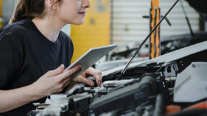 Female mechanic running a diagnostic on a car engine