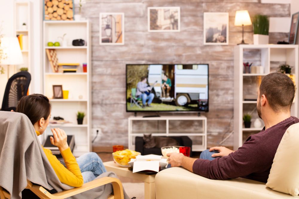 dvoje ljudi gledaju tv